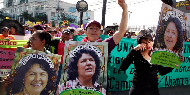 Women carry images of slain environmental activist Berta Caceres during the commemoration of International Women's Day in Tegucigalpa, Honduras, Tuesday, March 8, 2016. Caceres, a Lenca Indian activist who won the 2015 Goldman Environmental Prize for her role in fighting a dam project was killed by unknown assailants on March 3, 2016. She had previously complained of receiving death threats from police, soldiers and local landowners because of her work. (AP Photo/Fernando Antonio)