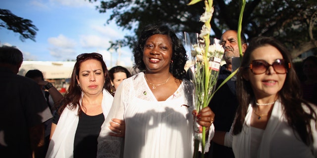 CORAL GABLES, FL - APRIL 27: Berta Soler, co-founder of the Ladies in White, (C) and current leader of the Cuban opposition group walks with Janisset Rivero (L) and others as she visits with Cuban exiles during an event at Merrick Park on April 27, 2013 in Coral Gables, Florida. In Cuba Solerâs group is made up of wives and mothers and was formed in 2003 after the arrests of 75 government opponents. (Photo by Joe Raedle/Getty Images)