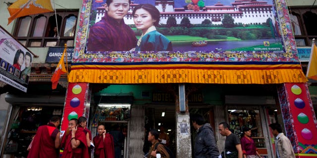 Una gran pancarta del rey Jigme Khesar Namgyal Wangchuck y la futura reina Jetsun Pema se ve en un escaparate en la capital de Thimphu, Bután, el miércoles 12 de octubre de 2011. El monarca reformista de 31 años del pequeño reino del Himalaya se casará con su plebeya esposa en una serie de ceremonias previstas para el jueves.