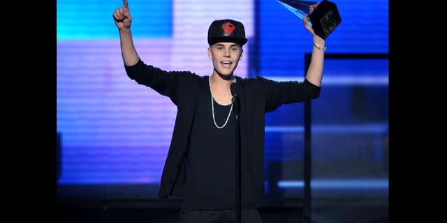 Nov. 18, 2012: File photo, Justin Bieber accepts the award for favorite album - pop/rock for "Believe" at the 40th Anniversary American Music Awards, in Los Angeles. A Los Angeles appellate panel wrote in a preliminary statement filed Monday, Jan. 28, 2013, that a 2010 California anti-paparazzi statute is constitutional. The law was used to charge a photographer for chasing Bieber last year, but a judge dismissed the anti-paparazzi counts in November 2012 because he said the law is overly broad and unconstitutional.