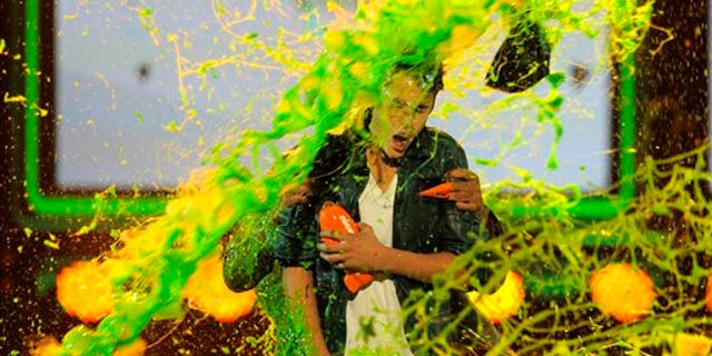 Justin Bieber gets slimed after accepting the award for favorite male singer onstage at Nickelodeon's 25th Annual Kids' Choice Awards.