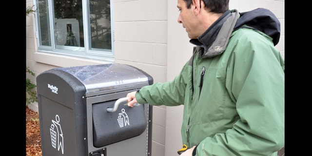 Dec. 5, 2012: Rich Valcourt checks on a BigBelly solar-powered waste disposal unit at Natick Soldier Systems Center, Mass. NSSC has 12 of the units positioned across the installation.
