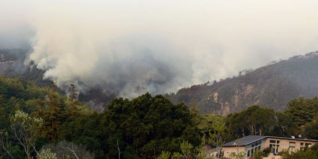December 16, 2013: Smoke rises above Pfeiffer Ridge in Big Sur, Calif. The wildfire burning Monday in the Big Sur area of California destroyed at least 15 homes and forced about 100 people to evacuate as it chewed through dry vegetation on its way toward the ocean. (AP Photo/Nic Coury)