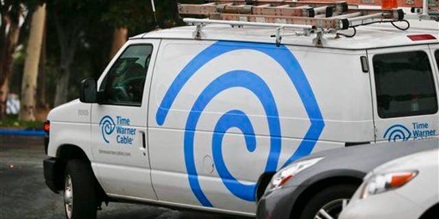 A Time Warner Cable service truck works its way through traffic May 27, 2015, in Carlsbad, Calif.