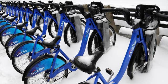 FILE- In this Feb. 5, 2014 file photo, snow covers a CitiBike bike rack, in the Brooklyn borough of New York. Citing spotty maintenance and poorly cleaned bikes, a new audit by City Comptroller Scott Stringer found that New York City Bike Share has done a poor job of operating and maintainng the Citi Bike program. (AP Photo/Mark Lennihan, File)