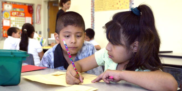 CHICAGO, IL - JULY 2: Students work together in teacher Daisy Moran's second-grade bilingual class during summer school at Mozart School July 2, 2003 in Chicago, Illinois. A record number of students are expected at summer school due to a strong showing for a new voluntary program for mid-tier students and strict application of non-ITBS (Iowa Tests of Basic Skills) test promotion standards. (Photo by Tim Boyle/Getty Images)