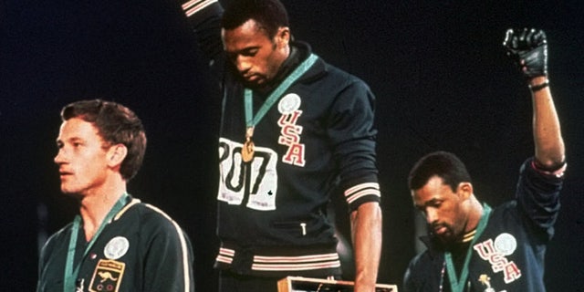 In this file photo, United States gold medalist Tommie Smith, center, and bronze medalist John Carlos, right, stare downward while extending their gloved hands skyward in racial protest alongside Australian silver medalist Peter Norman during the playing of "The Star-Spangled Banner" following the 200-meter race at the Mexico City Summer Olympics.(AP)