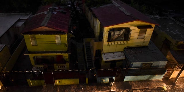 Vehicle lights illuminate a street after a massive blackout, in San Juan, Puerto Rico, Thursday, Sept. 22, 2016. Puerto Ricans faced another night of darkness Thursday as crews slowly restored electricity a day after a fire at a power plant caused the aging utility grid to fail and blacked out the entire island. (AP Photo/Carlos Giusti)
