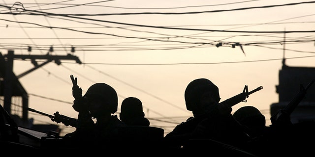 Brazilian soldiers keep watch in the unpacified Complexo da Maré, one of the largest 'favela' complexes in Rio de Janeiro, Brazil, on March 30, 2014.