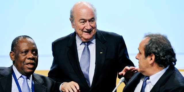 FILE - In this May 25, 2012 file photo Confederation of African Football, CAF, President Issa Hayatou, left, FIFA President Joseph Blatter, center, and UEFA President Michel Platini during the second day session of the 62nd FIFA Congress in Budapest, Hungary. Sepp Blatter and Michel Platini have been banned for 8 years, the FIFA ethics committee said Monday, Dec. 21, 2015. (Laszlo Beliczay/MTI via AP, file)
