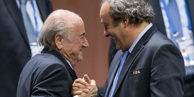 FILE - In this Friday, May 29, 2015 file photo, FIFA president Sepp Blatter is greeted by UEFA President Michel Platini, right, after Blatters re-election as president at the Hallenstadion in Zurich, Switzerland. Sepp Blatter and Michel Platini have been banned for 8 years, the FIFA ethics committee said Monday, Dec. 21, 2015. (Patrick B. Kraemer/Keystone via AP, File)