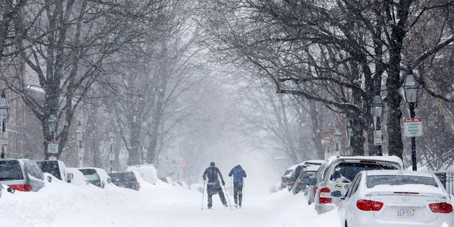 Two people cross-country ski up Marlborough Street during a blizzard in Boston, Massachusetts Jan. 27, 2015.