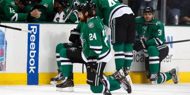Dallas Stars right wing Alex Chiasson (12) bows his head on the bench as defenseman Jordie Benn (24) takes a knee on the ice after play was stopped in the first period of an NHL Hockey game against the Columbus Blue Jackets, Monday, March 10, 2014, in Dallas. Stars center Rich Peverly was taken to a hospital after a medical emergency. (AP Photo/Sharon Ellman)