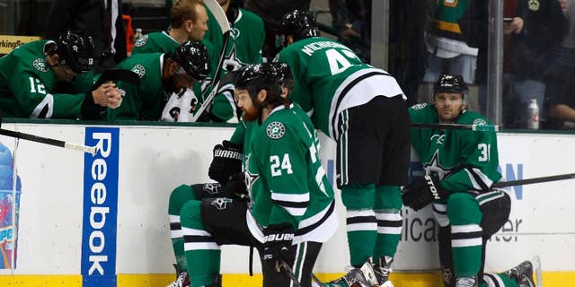 Dallas Stars right wing Alex Chiasson (12) bows his head on the bench as defenseman Jordie Benn (24) takes a knee on the ice after play was stopped in the first period of an NHL Hockey game against the Columbus Blue Jackets, Monday, March 10, 2014, in Dallas. Stars center Rich Peverly was taken to a hospital after a medical emergency. (AP Photo/Sharon Ellman)