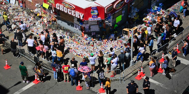 Mourners gather at a community memorial outside a bodega in New York on Tuesday, June 26, 2018, where 15-year-old Lesandro Guzman-Feliz was killed in a machete attack days earlier.
