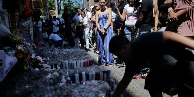 People leave candles and other mementos at a memorial to Lesandro Guzman-Feliz near the site of his murder in the Bronx five days after the June 20 murder.