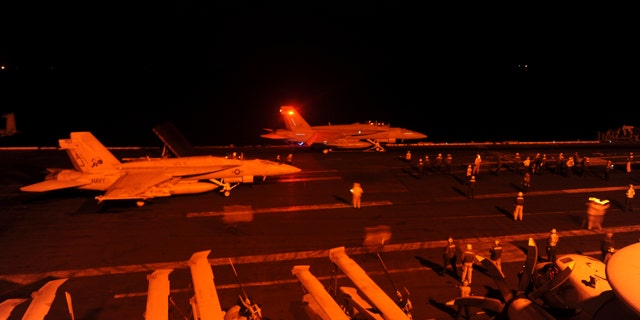 An F/A-18E Super Hornet, attached to Strike Fighter Squadron (VFA) 31, and an F/A-18F Super Hornet, attached to Strike Fighter Squadron (VFA) 213, prepare to launch from the flight deck of the aircraft carrier USS George H.W. Bush (CVN 77) to conduct strike missions against ISIL targets, in the Arabian Gulf.