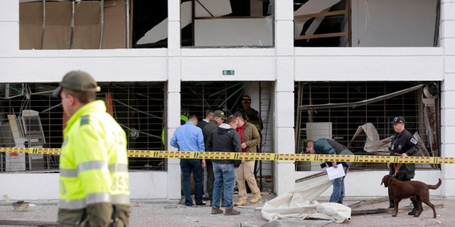 Police officers inspect an office after it was wrecked by an explosion in Bogota, Colombia, Thursday, July 2, 2015. A homemade explosive device went off in the financial district of Colombia's capital and wounded several people, while a second blast elsewhere in Bogota injured another, authorities said. (AP Photo/Fernando Vergara)