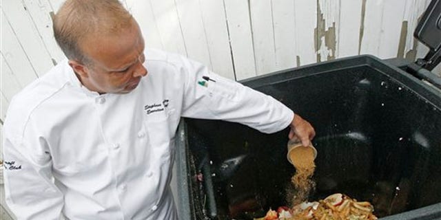 June 11, 2012: Executive chef Stephane Baloy scatters a mixture of microorganisms onto a container of composting scrap food at the Ferncroft Country Club in Middleton, Mass.