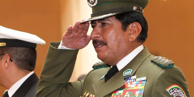 In this Jan. 24, 2010 photo, Bolivia's National Police Chief Col. Oscar Nina salutes during his swearing-in ceremony at the government palace in La Paz, Bolivia. One year prior, Nina was named anti-drug police chief. In March of 2015, the retired police general who reorganized Bolivia's counter-narcotics force after President Evo Morales expelled U.S. drug agents, is under investigation for illicit enrichment and drug trafficking ties. A judge was to decide Wednesday, March 4, 2015 whether Gen. Nina should be jailed. (AP Photo/Juan Karita)