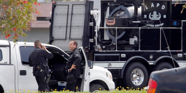 May 15, 2013: Los Angeles Police Department bomb squad officers gather at the site where police arrested a man after discovering explosive material in his car and potential explosive devices in his apartment.
