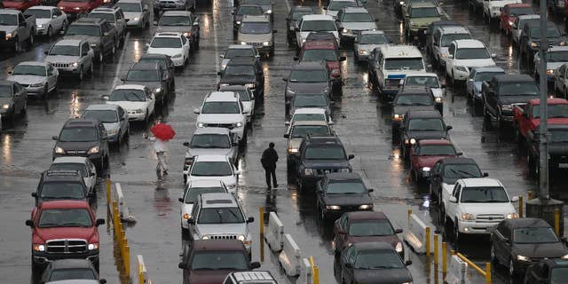 FILE - In this Dec. 3, 2014 file photo, cars wait to enter the United States from Tijuana, Mexico through the San Ysidro port of entry in San Diego. San Diego police say a 40-year-old man died after a border inspector shot him with a stun gun at the nation's busiest crossing. Police said Thursday, Dec. 25, 2014 that the man jumped over a counter and attacked an inspector after being escorted to a separate area for questioning at the San Ysidro port of entry between San Diego and Tijuana, Mexico and a records check revealed he was wanted on a felony charge. (AP Photo/Gregory Bull)