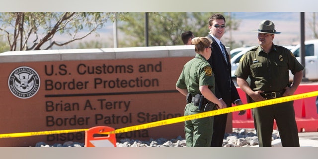 Border Patrol Agents and Secretary of Homeland Security Janet Napolitano's security detail stand guard outside the Brian A. Terry Border Patrol Station outside in Bisbee, Ariz. on Friday, Oct. 5, 2012. A preliminary investigation has found friendly fire likely was to blame in the shootings of two border agents along the Arizona-Mexico border, the FBI said Friday. (AP Photo/The Arizona Republic, David Wallace) MARICOPA COUNTY OUT; MAGS OUT; NO SALES