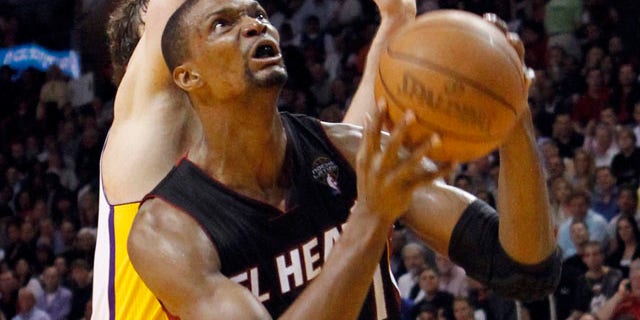 March 10: Miami Heat's Chris Bosh prepares to go to the basket as Los Angeles Lakers' Pau Gasol defends in the fourth quarter of the NBA basketball game in Miami. The Heat won 94-88.