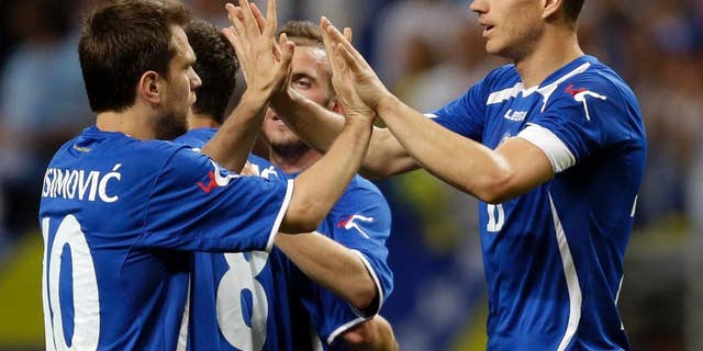 Bosnia-Herzegovina's Edin Dzeko, right, is congratulated by Zvjezdan Misimovic, left, after scoring during the second half in an international friendly soccer match against Ivory Coast on Friday, May 30, 2014, in St. Louis. Dzeko score both goals in the team's 2-1 victory. (AP Photo/Jeff Roberson)