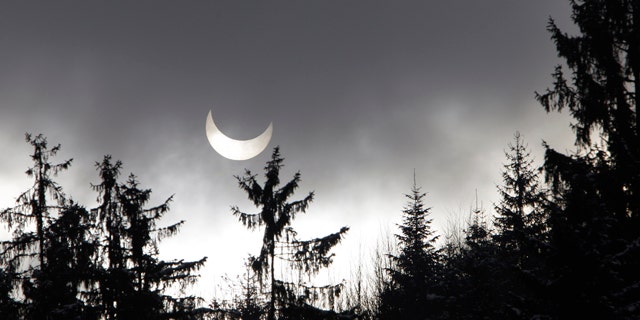 A partial solar eclipse is seen through clouds and snow flurries near Sarajevo, Bosnia , on Tuesday, Jan. 4, 2011. A partial solar eclipse began Tuesday in the skies over the Mideast and will extend across much of Europe.