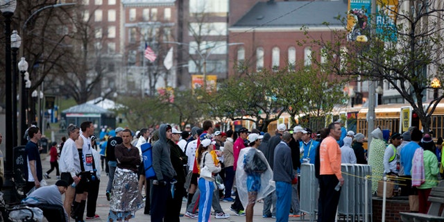 Runners cue to board busses ahead of the 118th Boston Marathon Monday, April 21, 2014 in Boston. (AP Photo/Matt Rourke)