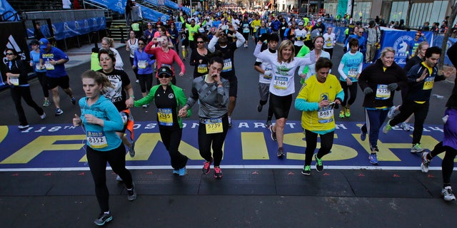 At the midpoint of the 5K race, runners cross the finish line of the Boston Marathon, Saturday, April 19, 2014, in Boston.