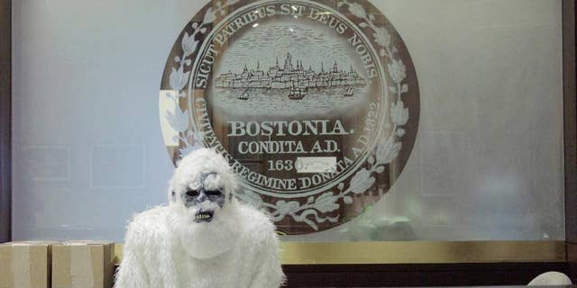 March 6, 2015: In this file photo provided by Eric Gulliver, an anonymous creature known as The Boston Yeti poses in front of the Boston logo at City Hall in Boston.