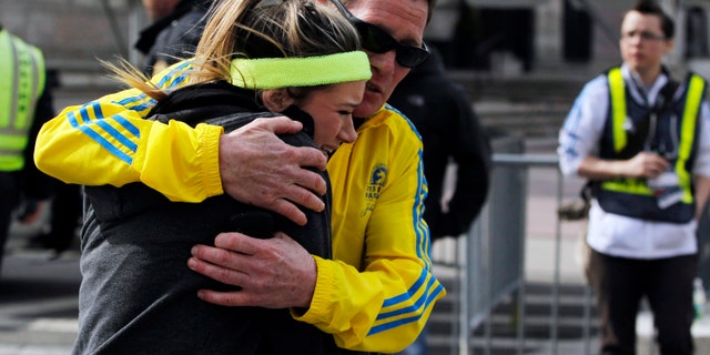 A woman is comforted by a man near a triage tent set up for the Boston Marathon after explosions went off at the 117th Boston Marathon in Boston, Massachusetts April 15, 2013.