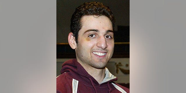 In this Feb. 17, 2010, photo, Tamerlan Tsarnaev, smiles after accepting the trophy for winning the 2010 New England Golden Gloves Championship from Dr. Joseph Downes, right, in Lowell, Mass.