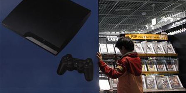 A boy chooses Sony's Playstation game software at an electronic shop in Tokyo May 5, 2011.