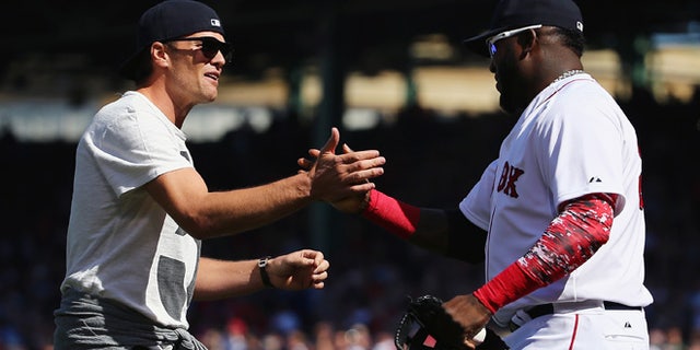 BOSTON, MA - APRIL 13: New England Patriots quarterback Tom Brady talks with David Ortiz #34 of the Boston Red Sox after throwing out the first pitch before the game against the Washington Nationals at Fenway Park on April 13, 2015 in Boston, Massachusetts. (Photo by Maddie Meyer/Getty Images)