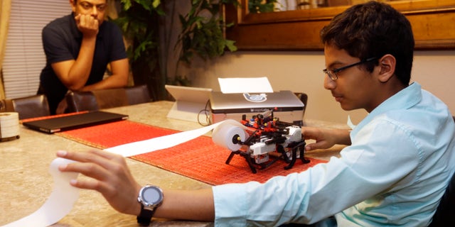 Jan. 6, 2015: Shubham Banerjee, right, world on his Lego robotics braille printer as his dad Neil watches at home in Santa Clara, Calif.