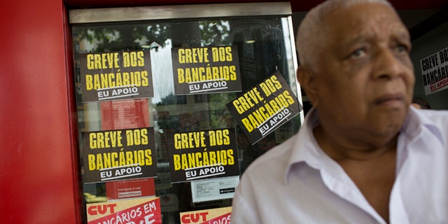 A man leaves the ATM of a striking bank, in Rio de Janeiro, Brazil, Wednesday, Oct. 5, 2016.