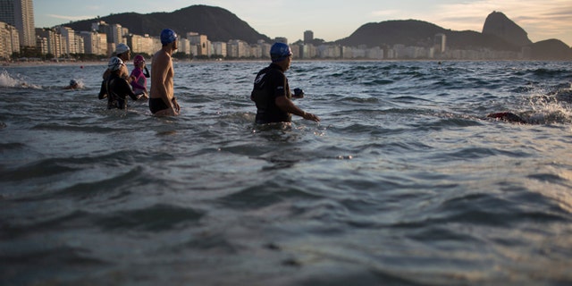 ATTN: PATRICK SISON - In this July 14, 2015 photo, beachgoers wade into the waters of Copacabana Beach in Rio de Janeiro, Brazil. An Associated Press analysis of water quality found not one water venue safe for swimming or boating in Rio's waters. Over 10,000 athletes from 205 countries are expected to compete in next years Summer Olympics. Hundreds of them will be sailing in the waters near Marina da Gloria in Guanabara Bay; swimming off Copacabana Beach; and canoeing and rowing on the brackish waters of the Rodrigo de Freitas Lake. (AP Photo/Leo Correa)