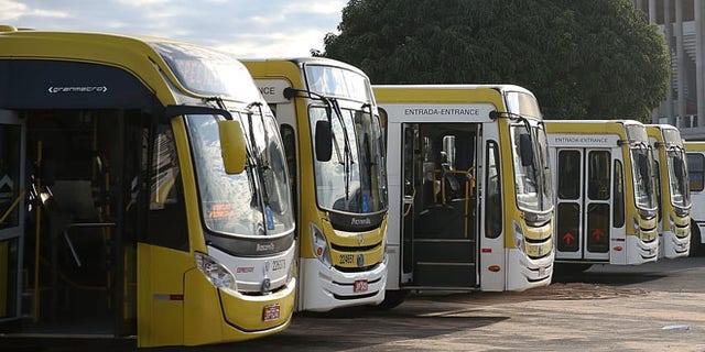 BRASILIA, BRAZIL - JUNE 03: Buses are parked in front of the 72,000-seat Mane Garrincha Stadium, which is now used primarily as a municipal bus parking lot, on June 3, 2015 in Brasilia, Brazil. Brazil constructed a number of expensive stadiums for the 2014 FIFA World Cup which now sit mostly empty in part because there is no popular local team to draw attendance. (Photo by Mario Tama/Getty Images)