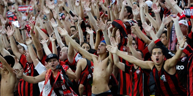 FILE - In this Nov.27, 2013 file photo, Atletico Paranaense fans cheer for their team during the Copa do Brazil final match against Flamengo in Rio de Janeiro, Brazil. Brazilians fans idolize their stars on the fields, courts and tracks. They'll cheer loudly at any sporting event they'll go to, be it a World Cup match, a Formula One race or a mixed martial arts fight. (AP Photo/Victor R. Caivano, File)