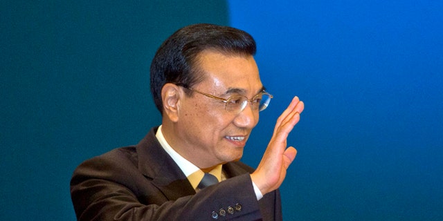 FILE - In this March 15, 2015, file photlo, Chinese Premier Li Keqiang waves as he arrives for a press conference at the end of the National People's Congress in Beijing's Great Hall of the People. Li Keqiang will accelerate plans for an ambitious railway linking Brazils Atlantic coast with a Pacific port in Peru, and announce billions in other investments and trade deals, when he visits Brasilia on Tuesday, May 19, 2015, kicking off a four-nation South American tour that includes Chile, Peru and Colombia. (AP Photo/Ng Han Guan, File)