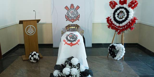 This undated photo released by the Corinthians soccer team shows an empty casket draped with the team's flag in Sao Paulo, Brazil. Corinthians says it’s building its own cemetery, complete with a mock football field and VIP tribunes where some of the team’s greatest players will be offered burial spaces. The “Corinthians Forever” cemetery is expected to open late in 2015, but fans can already start booking one of the 70,000 burial places available. (AP Photo/Ivo Duran, Corinthians)