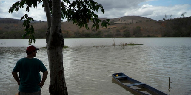 In this Oct. 11, 2016 photo, fisherman Deucimar Teixeira Lordes stands on the banks of the Doce River, in Mascarenhas, Brazil. The 45-year-old fisherman has doubts that he will fish in the Doce again. "Fishing here is not good anymore. I would not eat it and I don't have courage to sell it to the people." Lordes said. (AP Photo/Leo Correa)