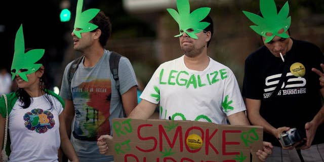 FILE - In this May 11, 2013 file photo, demonstrators wear cannabis shaped masks to support the legalization of marijuana in Rio de Janeiro, Brazil, during a march marking the 32 anniversary of Jamaican musician Bob Marley's death. Brazil's Supreme Court on Wednesday, Aug. 19, 2015 began debating a drug case that could lead to the decriminalization of drug possession for personal use. A final ruling is not expected for several days. (AP Photo/Felipe Dana, File)