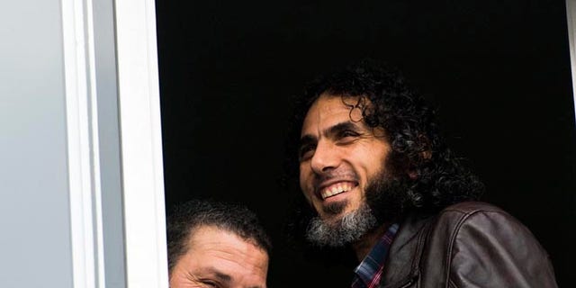 FILE - In this June 5, 2015 file photo, Abu Wa'el Dhiab, from Syria, right, and Adel bin Muhammad El Ouerghi, of Tunisia, both freed Guantanamo Bay detainees, stand next to the window of their shared home in Montevideo, Uruguay. The new U.S. ambassador in Uruguay expressed concern on Monday, July 11, 2016, about the lack of information on the whereabouts of Abu Wa'el Dhiab. (AP Photo/Matilde Campodonico, File)