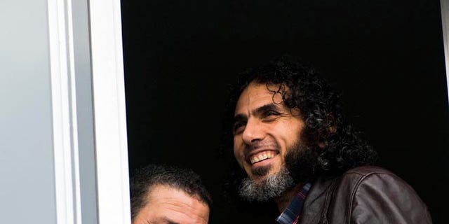 FILE - In this June 5, 2015 file photo, Abu Wa'el Dhiab, from Syria, right, and Adel bin Muhammad El Ouerghi, of Tunisia, both freed Guantanamo Bay detainees, stand next to the window of their shared home in Montevideo, Uruguay. The new U.S. ambassador in Uruguay expressed concern on Monday, July 11, 2016, about the lack of information on the whereabouts of Abu Wa'el Dhiab. (AP Photo/Matilde Campodonico, File)