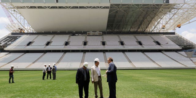 Jerome Valcke, Secretary General of FIFA, right, and Aldo Rebelo, Brazil Sports Minister, center, inspect Arena de Sao Paulo stadium, in Sao Paulo, Brazil, Monday, Jan. 20, 2014. Members of FIFA and the 2014 World Cup Local Organizing Committee started an inspection tour of stadiums in host cities across Brazil. (AP Photo/Nelson Antoine)