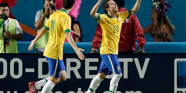 Brazil forward Bernard (20) celebrates his goal with midfielder Oscar (11) during the first half of an international friendly soccer game against Honduras, Saturday, Nov. 16, 2013, in Miami Gardens, Fla. (AP Photo/Wilfredo Lee)